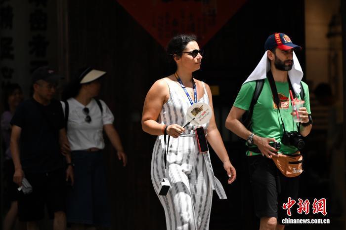 8月28日，外国游客冒高温在重庆十八梯传统风貌区游玩。中新社记者 何蓬磊 摄