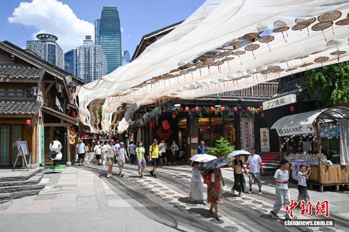 8月28日，游客冒高温在重庆十八梯传统风貌区游玩。中新社记者 何蓬磊 摄