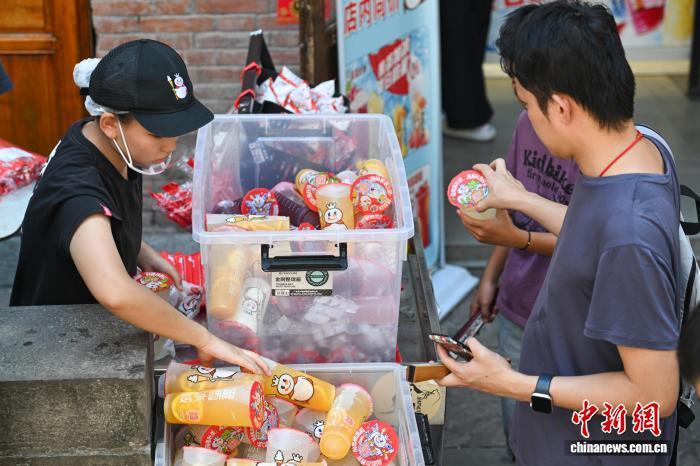 8月28日，游客在重庆十八梯传统风貌区购买冷饮。中新社记者 何蓬磊 摄